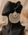 beige round crochet statement earring displayed on a black jewellery bust with a gold-tone stainless steel hook.