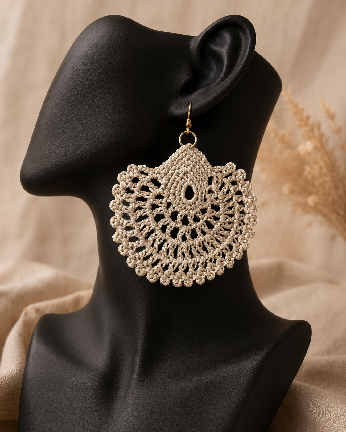 beige round crochet statement earring displayed on a black jewellery bust with a gold-tone stainless steel hook.