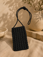 Black handmade paper yarn crochet phone bag with a long crossbody strap.