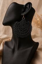 Black round crochet statement earring displayed on a black jewellery bust with a gold-tone stainless steel hook.