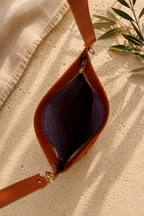 Open top view of the cognac brown crossbody bag showing its zip closure and lined interior.