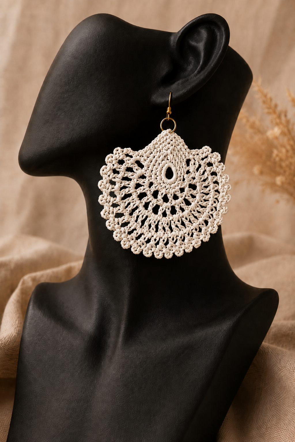 Cream round crochet statement earring displayed on a black jewellery bust with a gold-tone stainless steel hook.