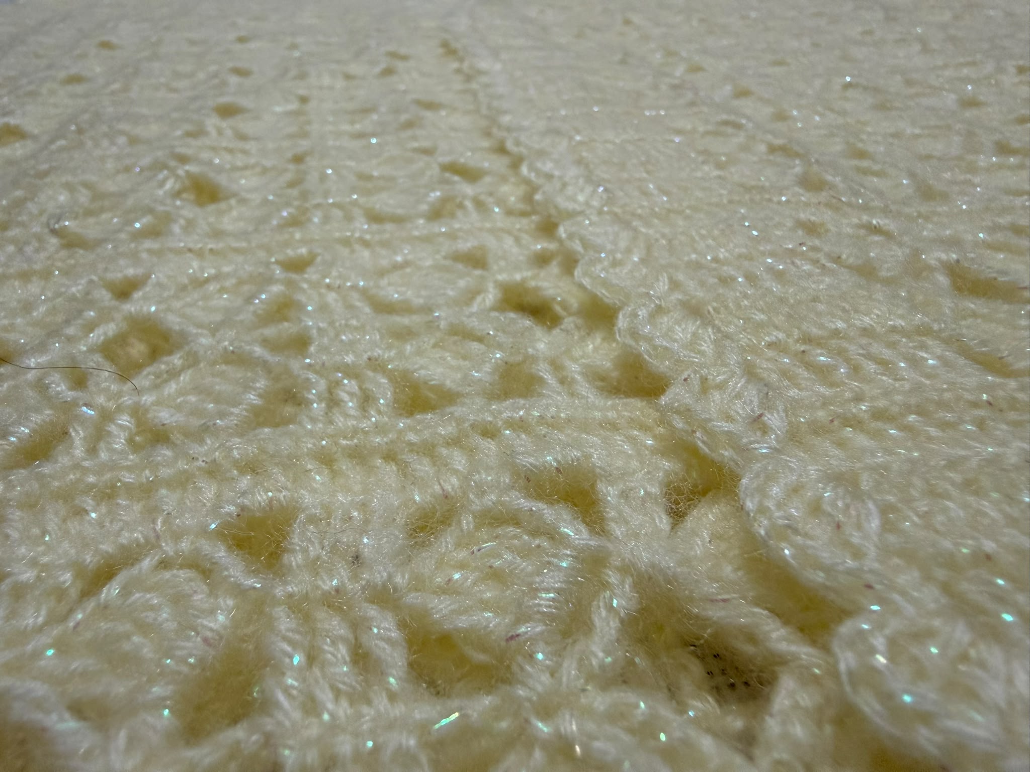 Macro view of the cream crochet vest made with Alize Angora Gold Simli yarn, showing its soft texture and delicate shimmer.