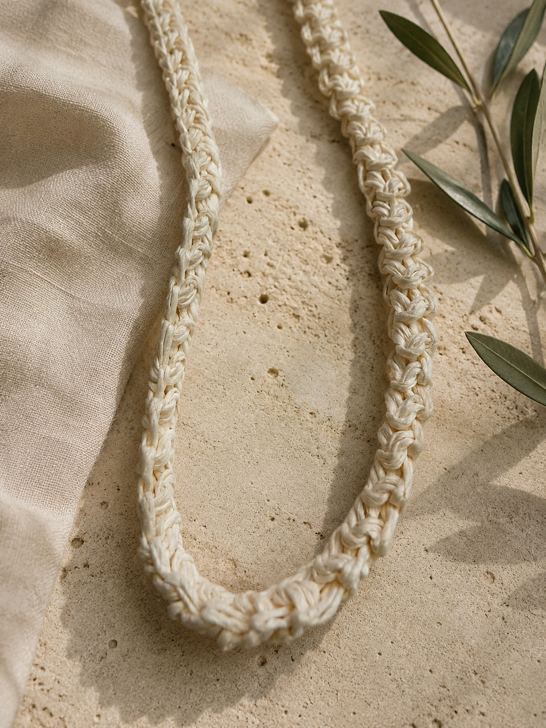 Close-up of the long crochet strap and open top of the paper yarn phone bag.