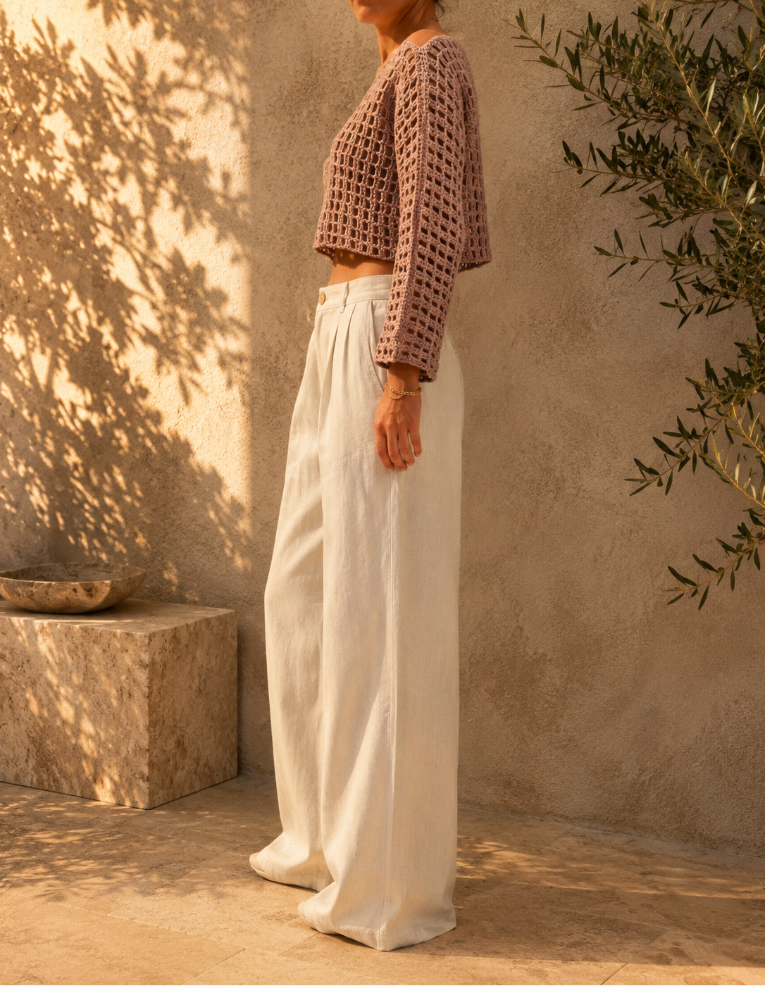 Side view of the handmade crochet crop top showing its straight sleeve shape and relaxed cropped silhouette.