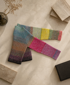 Back flat-lay view of the one-of-a-kind crochet cardigan showing the extended sleeves and hand-composed multicolour gradient transitions.