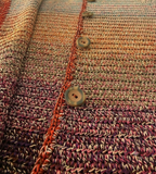 Close-up of a functional button, contrasting front placket and densely worked single crochet texture.
