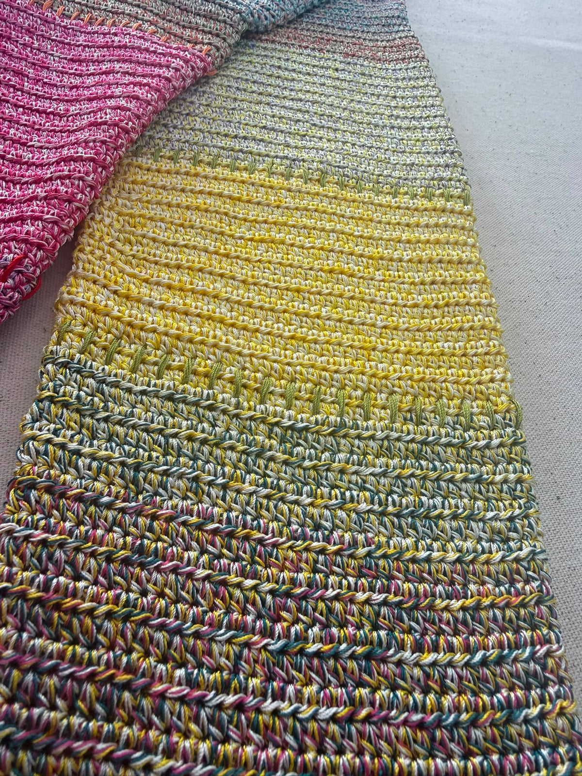 Close-up of the cardigan sleeve showing gradual transitions through yellow, blue, green and deeper blended tones.