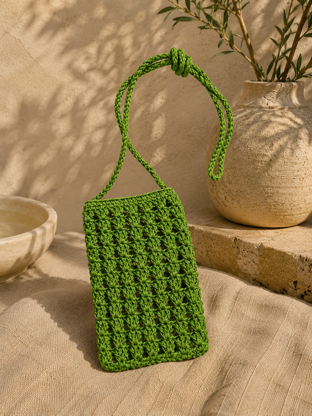Green handmade paper yarn crochet phone bag with a long crossbody strap.