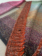 Detailed view of the openwork front placket worked in warm tones against the dense five-strand crochet body.