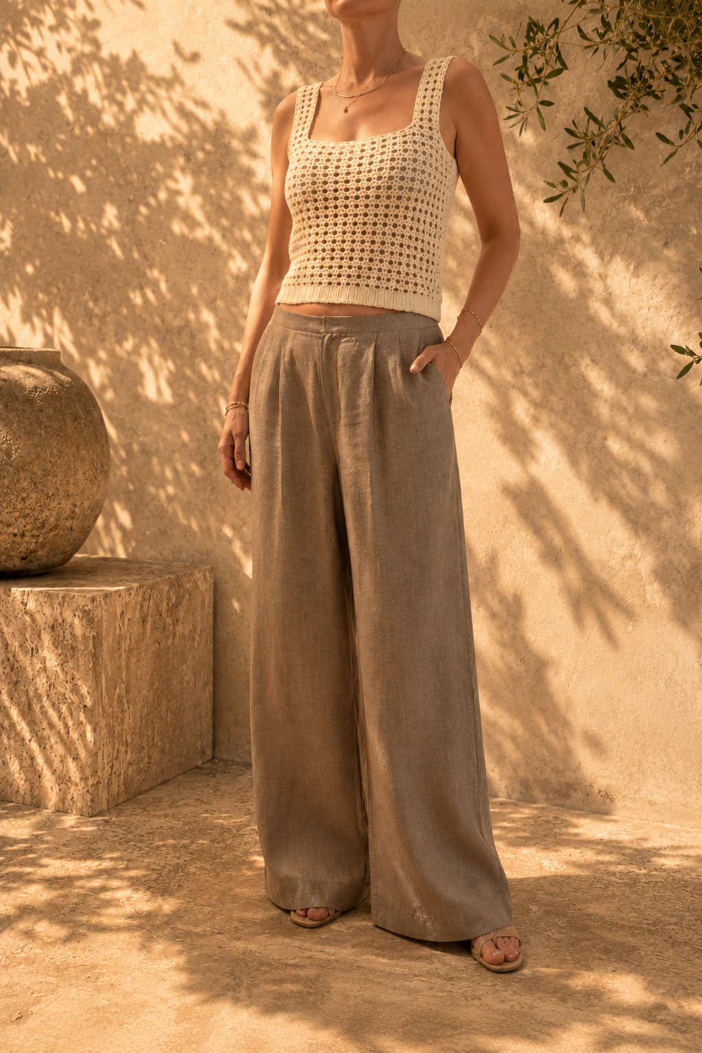 Handmade ivory crochet tank top with a square neckline, styled with wide-leg trousers in warm natural light.