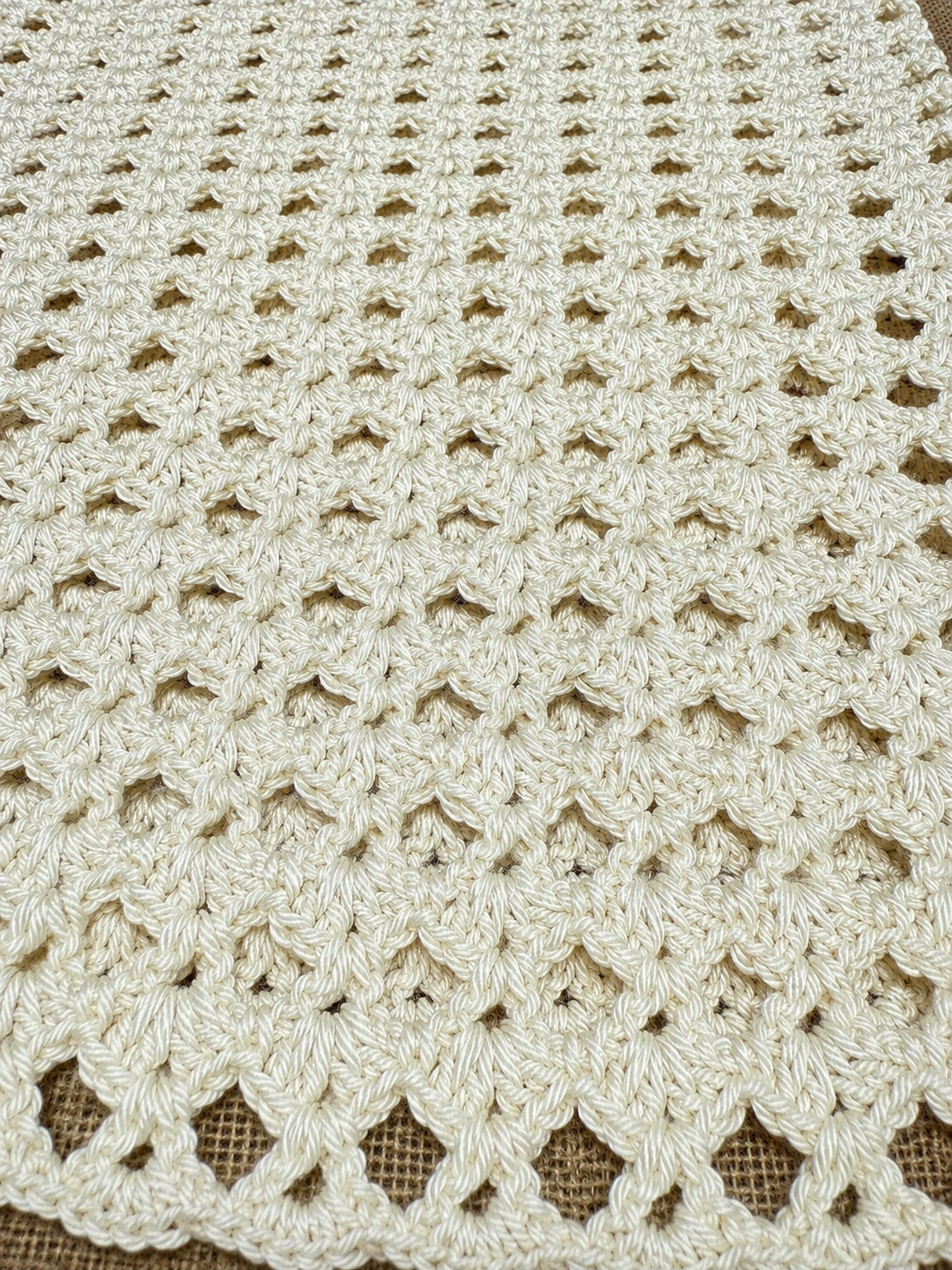 Detailed view of the lower crochet texture and openwork pattern worked in ivory Alize Diva yarn.