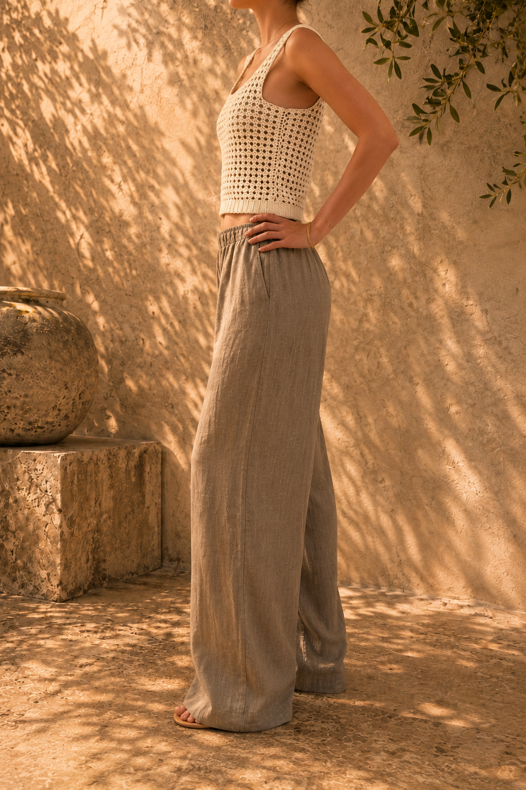 Side view of the ivory crochet tank top showing its straight silhouette, wide strap and hip-length fit.