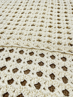 Close-up of the ivory crochet tank top showing the transition from close-set stitches to decorative openwork.