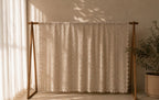 Full hanging display of the large ecru crochet tablecloth showing its rectangular proportions and openwork construction.