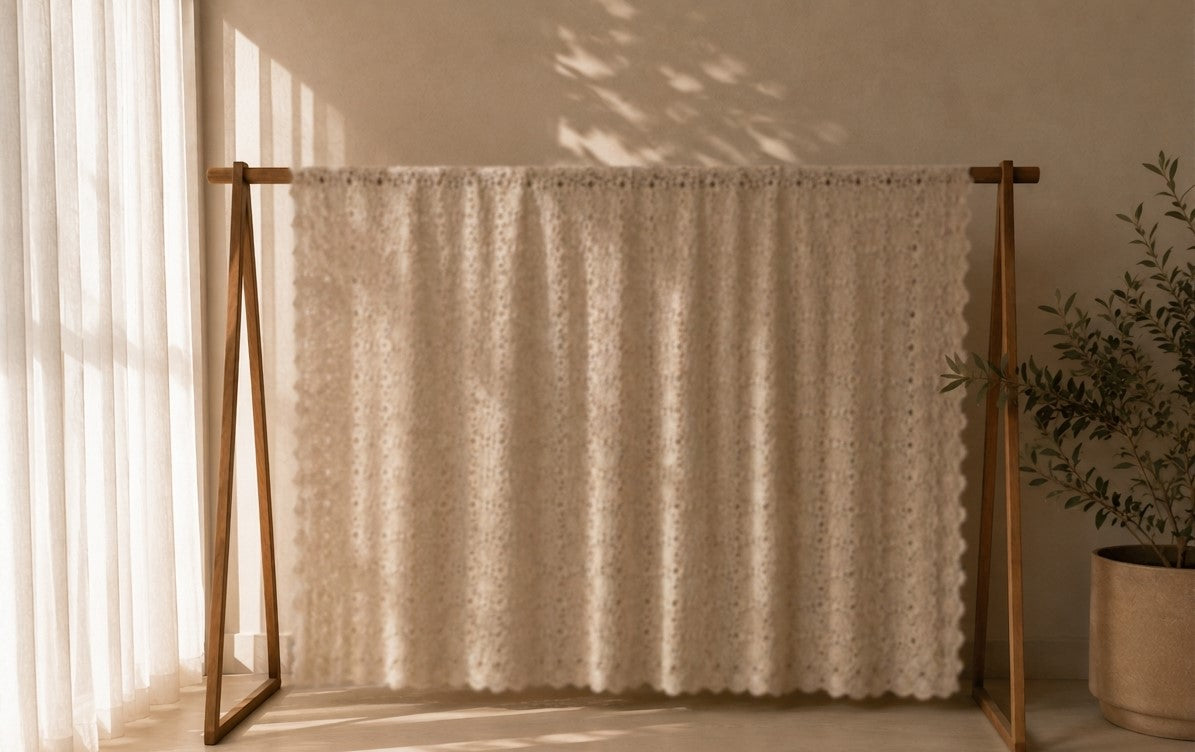 Full hanging display of the large ecru crochet tablecloth showing its rectangular proportions and openwork construction.