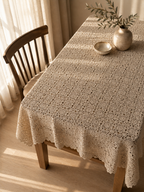 Elevated view of the large ecru crochet tablecloth covering a rectangular table and falling naturally over the sides.