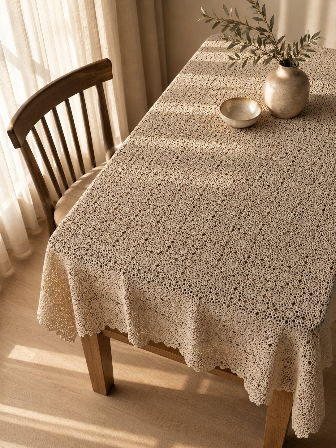 Elevated view of the large ecru crochet tablecloth covering a rectangular table and falling naturally over the sides.