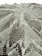 Detailed view of the floral and openwork crochet lace made from fine white mercerized cotton thread.