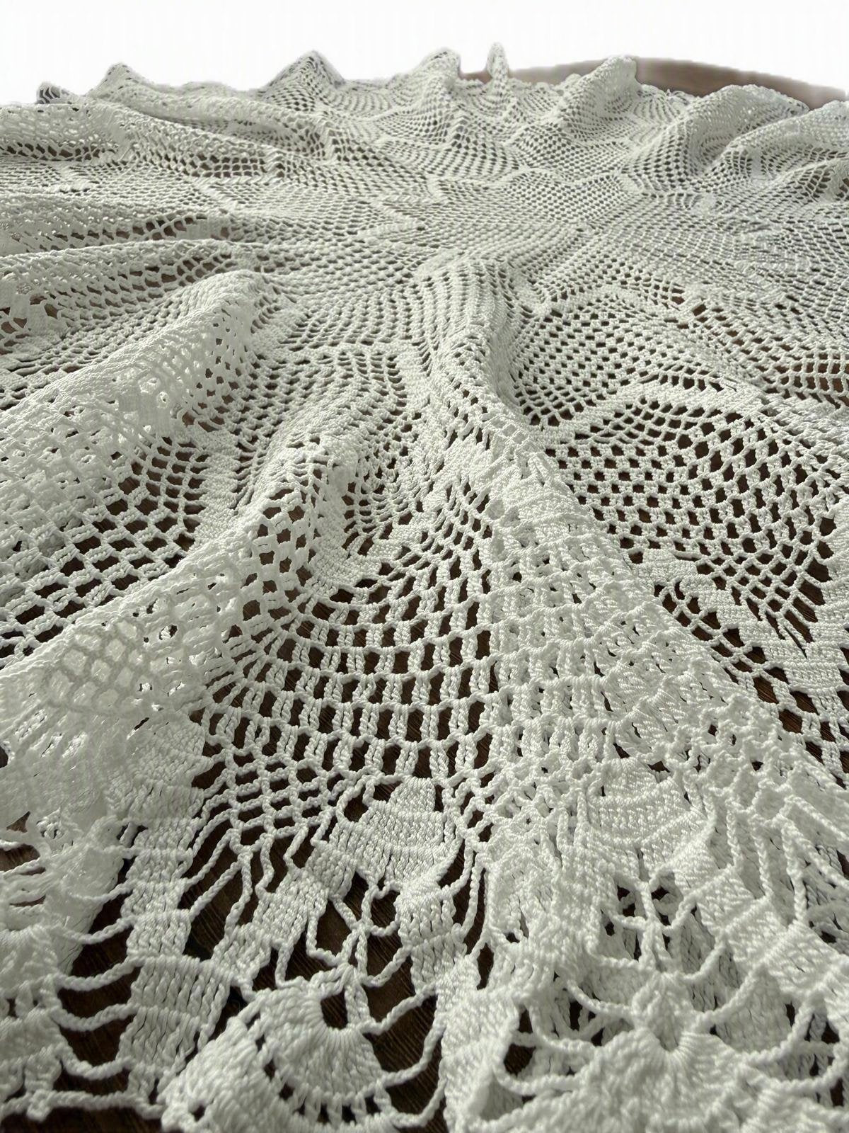 Detailed view of the floral and openwork crochet lace made from fine white mercerized cotton thread.