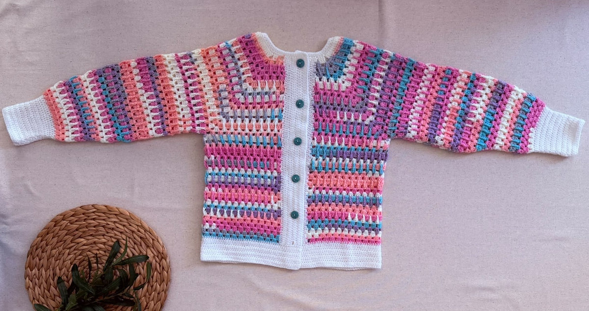 Full flat-lay front view of the multicolour crochet cardigan showing its long sleeves, button placket, cuffs and white hem.