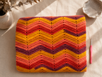 Folded handmade chevron crochet blanket showing the natural colour transitions of the Alize Batik yarn.
