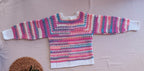 Full flat-lay back view of the handmade multicolour crochet cardigan showing the continuous striped pattern and overall proportions.