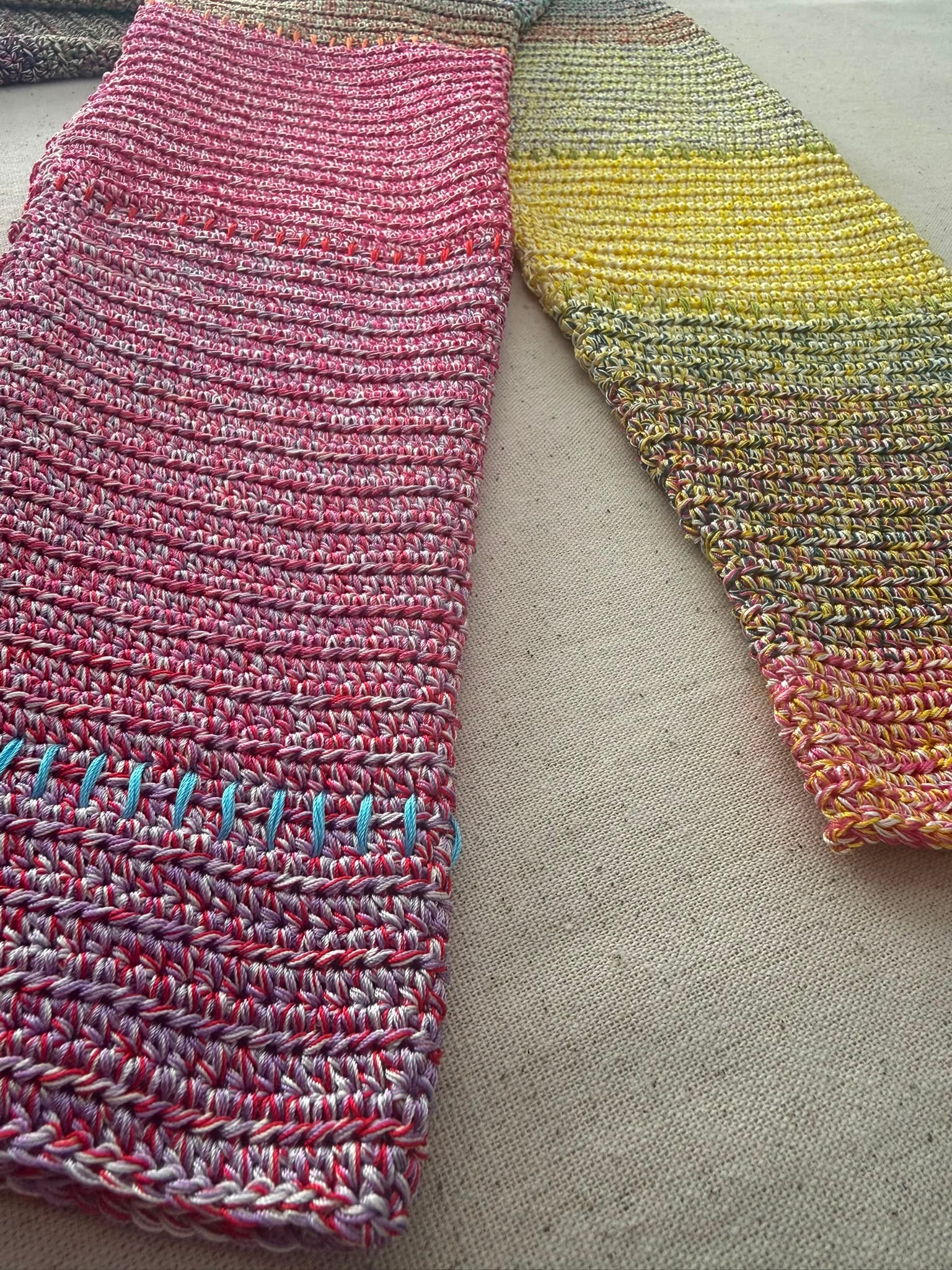 Close-up of the pink crochet sleeve and cuff with a contrasting blue joining detail.