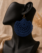 Navy round crochet statement earring displayed on a black jewellery bust with a gold-tone stainless steel hook.