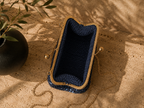 Open view of the navy handmade crochet evening bag showing the unlined interior and rose gold-tone kiss-lock frame.