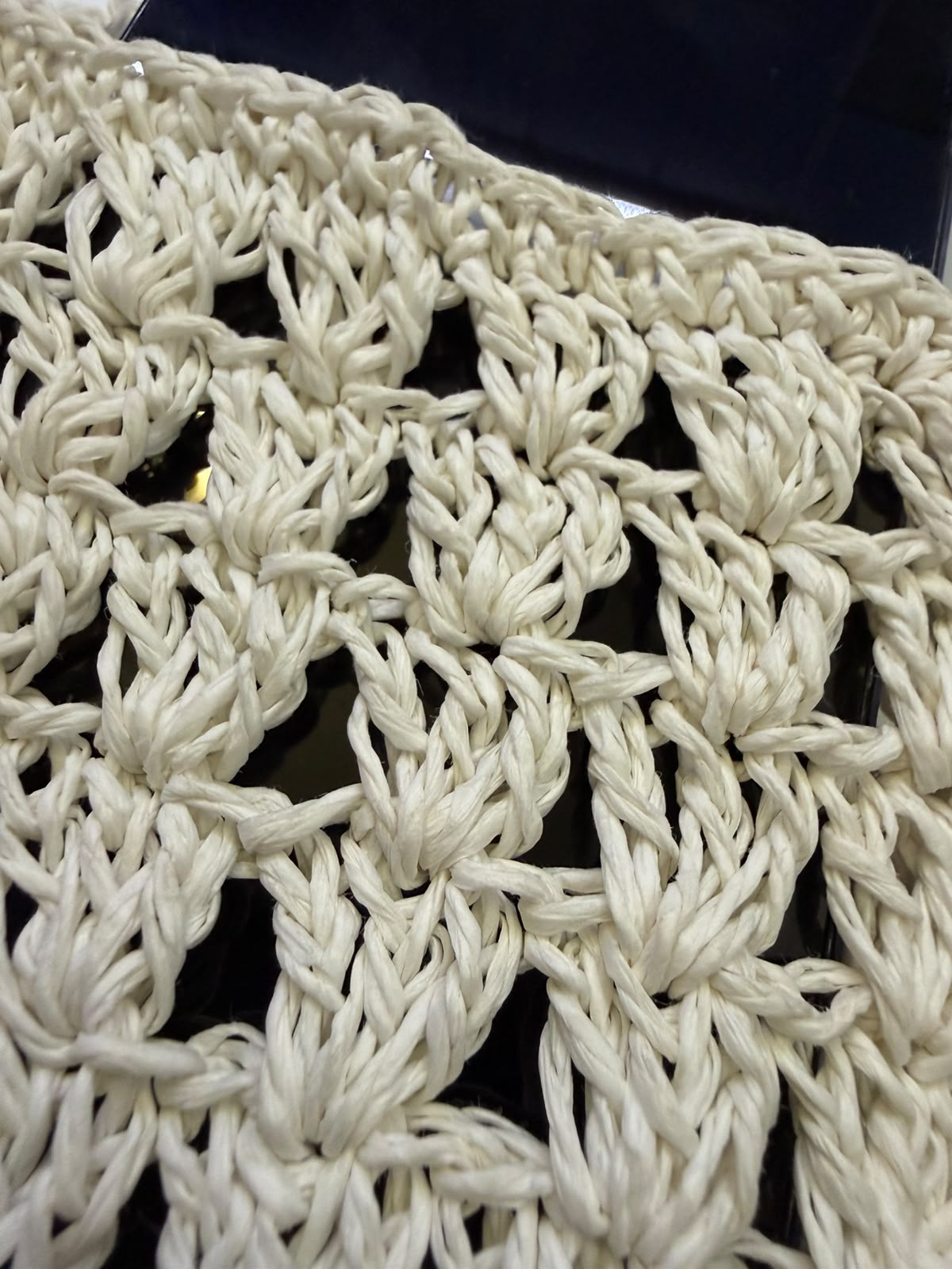 Close-up of the open crochet pattern and handmade paper yarn texture.