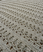 Close-up of the tunic’s alternating open crochet rows and denser textured stitches worked in taupe-grey yarn.