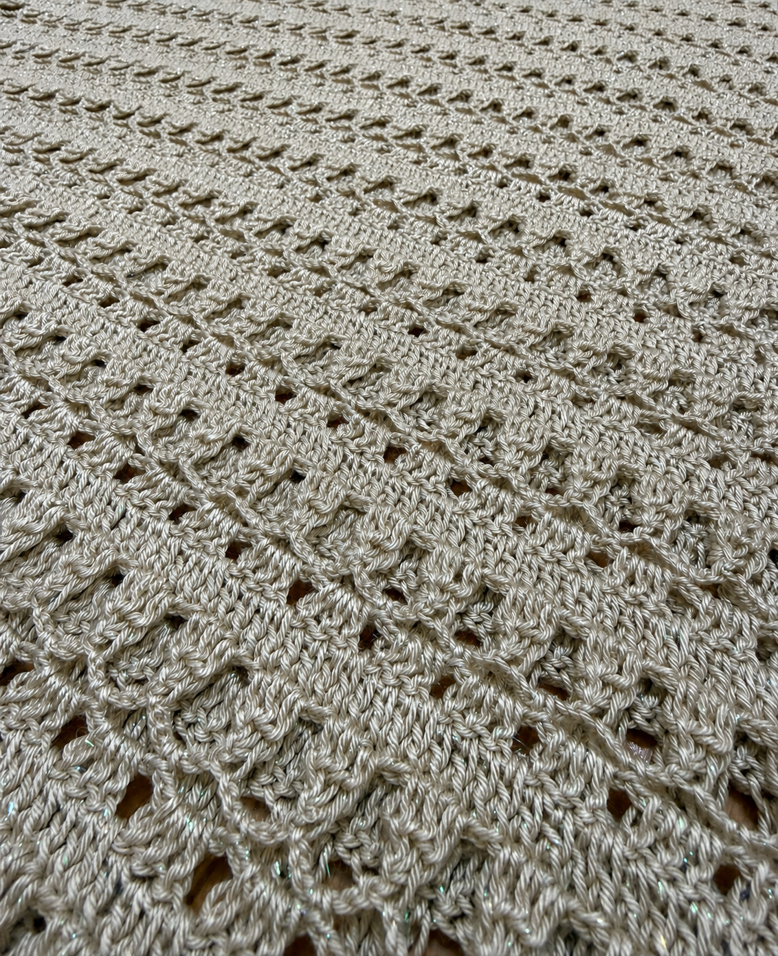 Close-up of the tunic’s alternating open crochet rows and denser textured stitches worked in taupe-grey yarn.