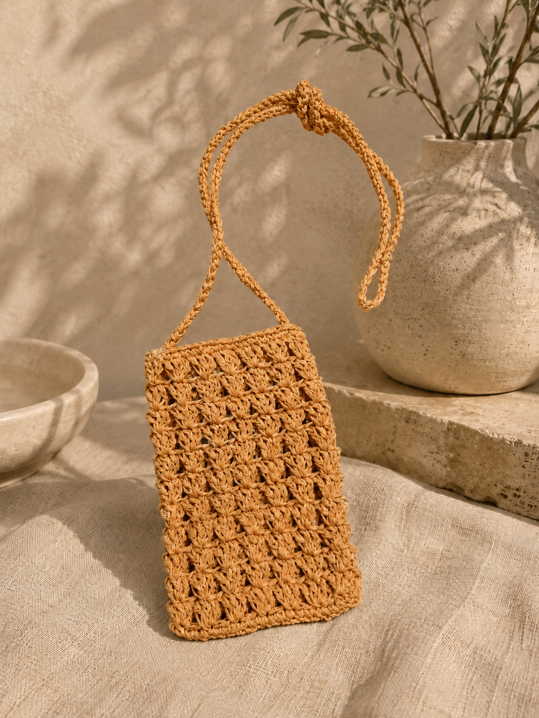 Orange handmade paper yarn crochet phone bag with a long crossbody strap.