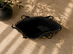 Open top view of the handmade paper yarn handbag showing its black structured lining and zippered interior opening.