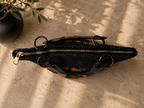 Top view of the structured paper yarn handbag showing the rose gold-tone zipper, black handles and narrow zipped opening.