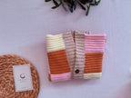 Folded front view of the handmade patchwork crochet cardigan showing the V-shaped placket, four-button closure and front block layout.