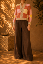 Three-quarter side view of the multicolour crochet cardigan showing its relaxed silhouette, long sleeves and patchwork colour blocks.