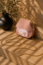 Powder pink handmade crochet evening bag with partial sequin detailing, a rose gold-tone kiss-lock frame and detachable chain strap.