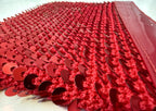 Close-up detail of the red sequin surface on the handmade clutch bag.