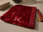 Side profile of the handmade red sequin clutch bag showing its slim shape.