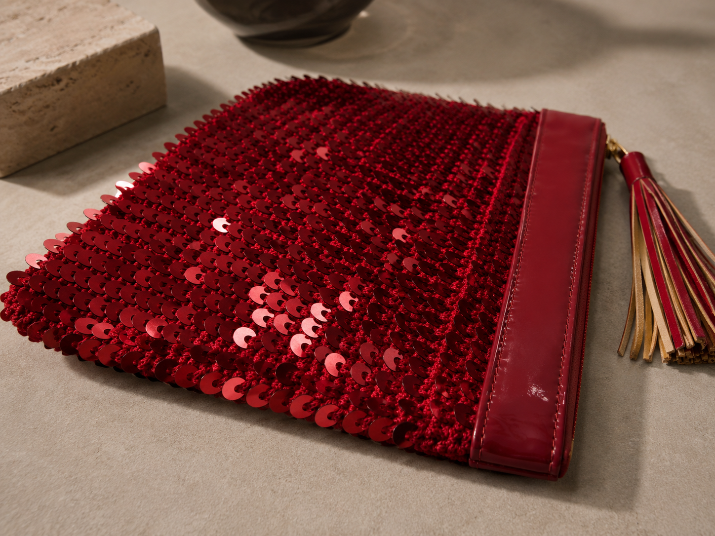 Side profile of the handmade red sequin clutch bag showing its slim shape.