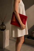 Handmade red sequin clutch bag styled under the arm with a neutral outfit.