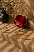 Red handmade crochet evening bag with partial sequin detailing, a rose gold-tone kiss-lock frame and detachable chain strap.