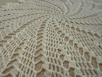 Close-up of the white crochet pattern radiating from the centre toward the decorative outer points.