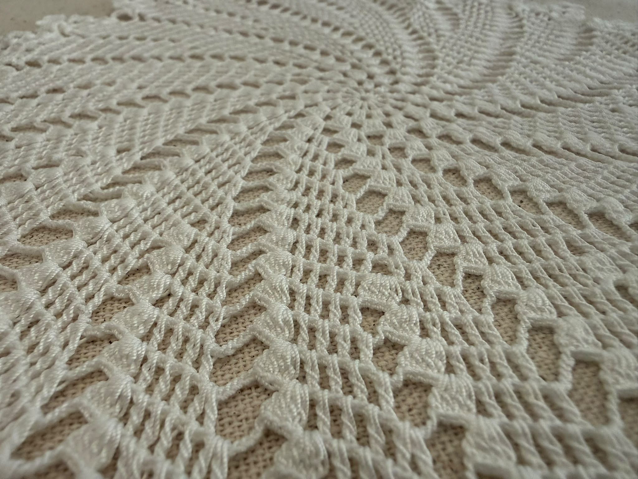 Close-up of the white crochet pattern radiating from the centre toward the decorative outer points.