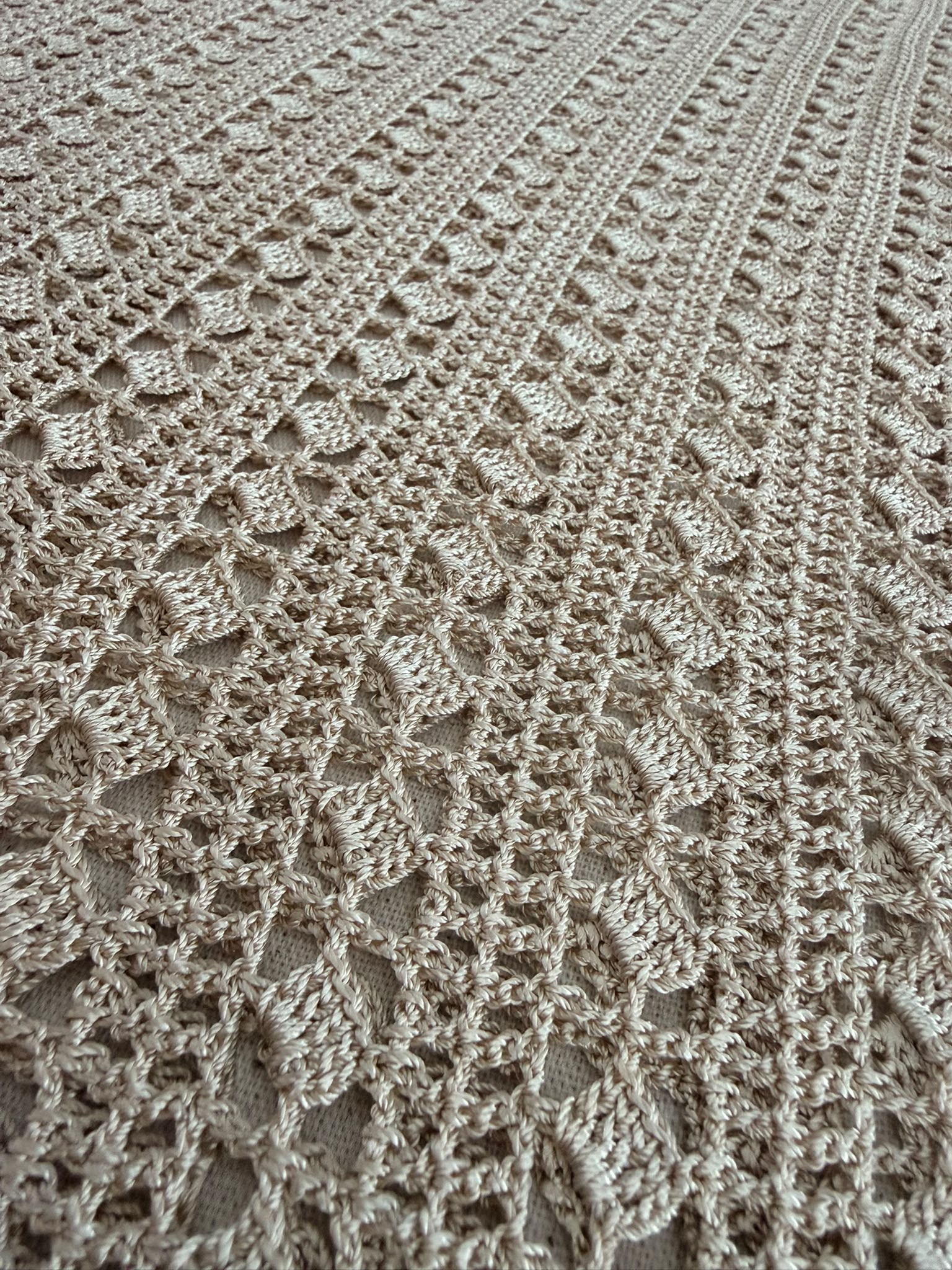 Detailed view of the sand-beige crochet blouse body showing the eleven repeating openwork rows and handmade stitch texture.
