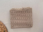 Folded view of the sand-beige crochet blouse highlighting the repeating openwork rows and clear polyester stitch definition.