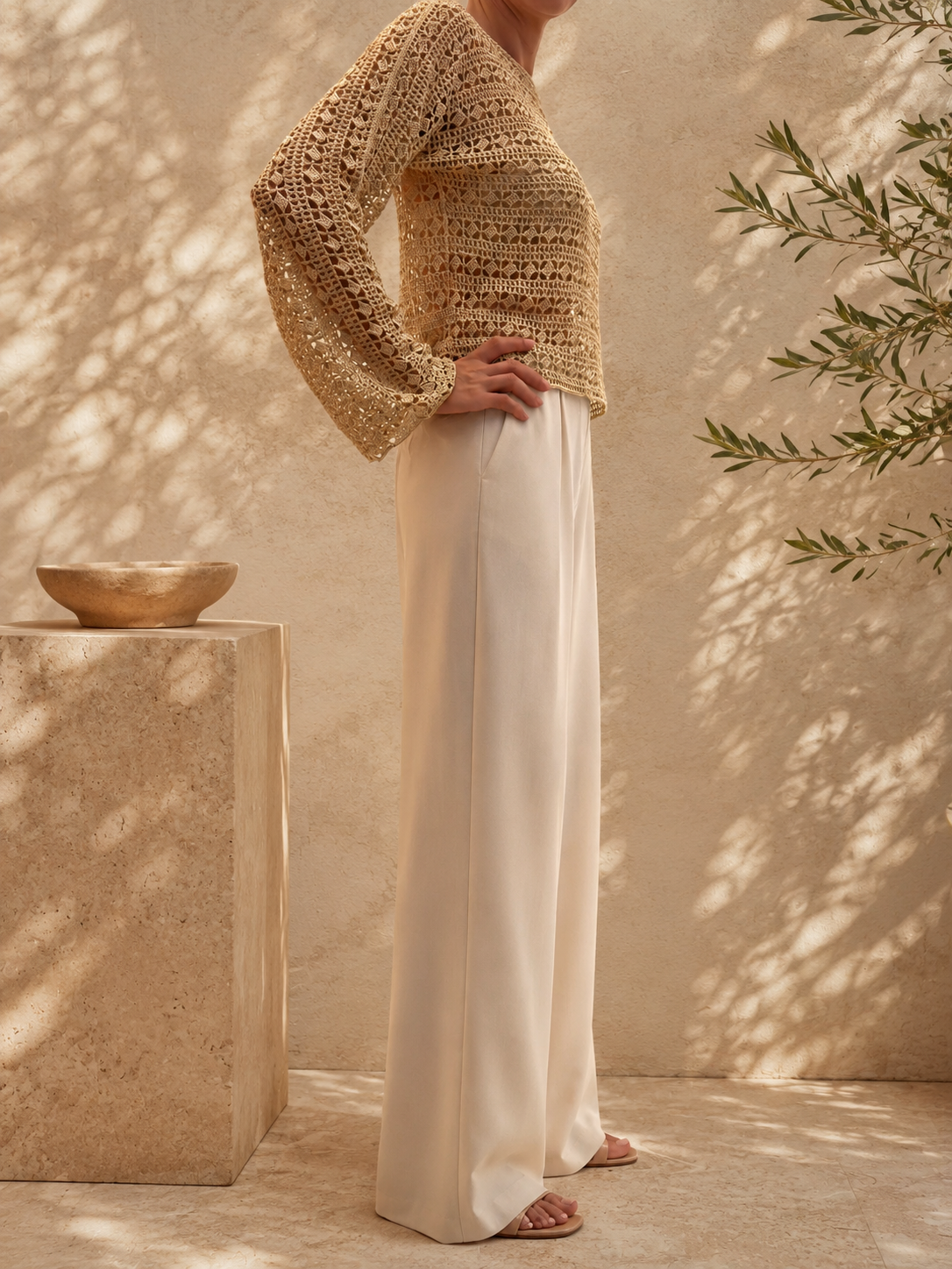 Three-quarter view of the handmade crochet blouse highlighting its warm sand-beige colour, wide neckline and textured openwork surface.