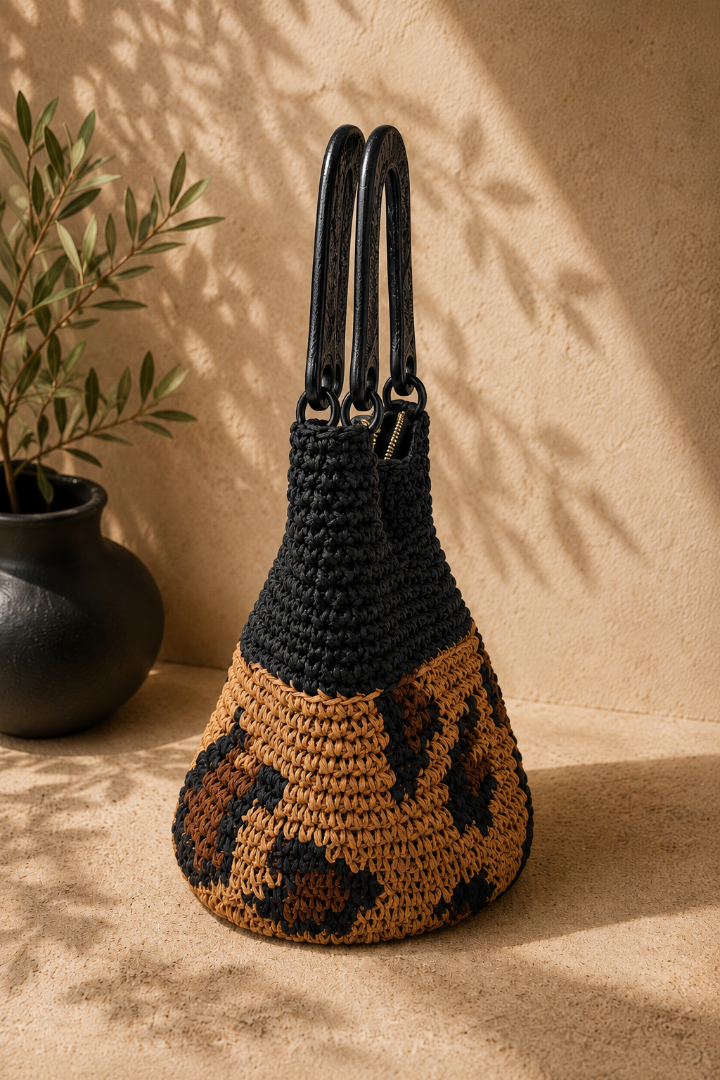 Side profile of the structured paper yarn handbag showing its tapered crochet body, rigid handles and oval-base construction.